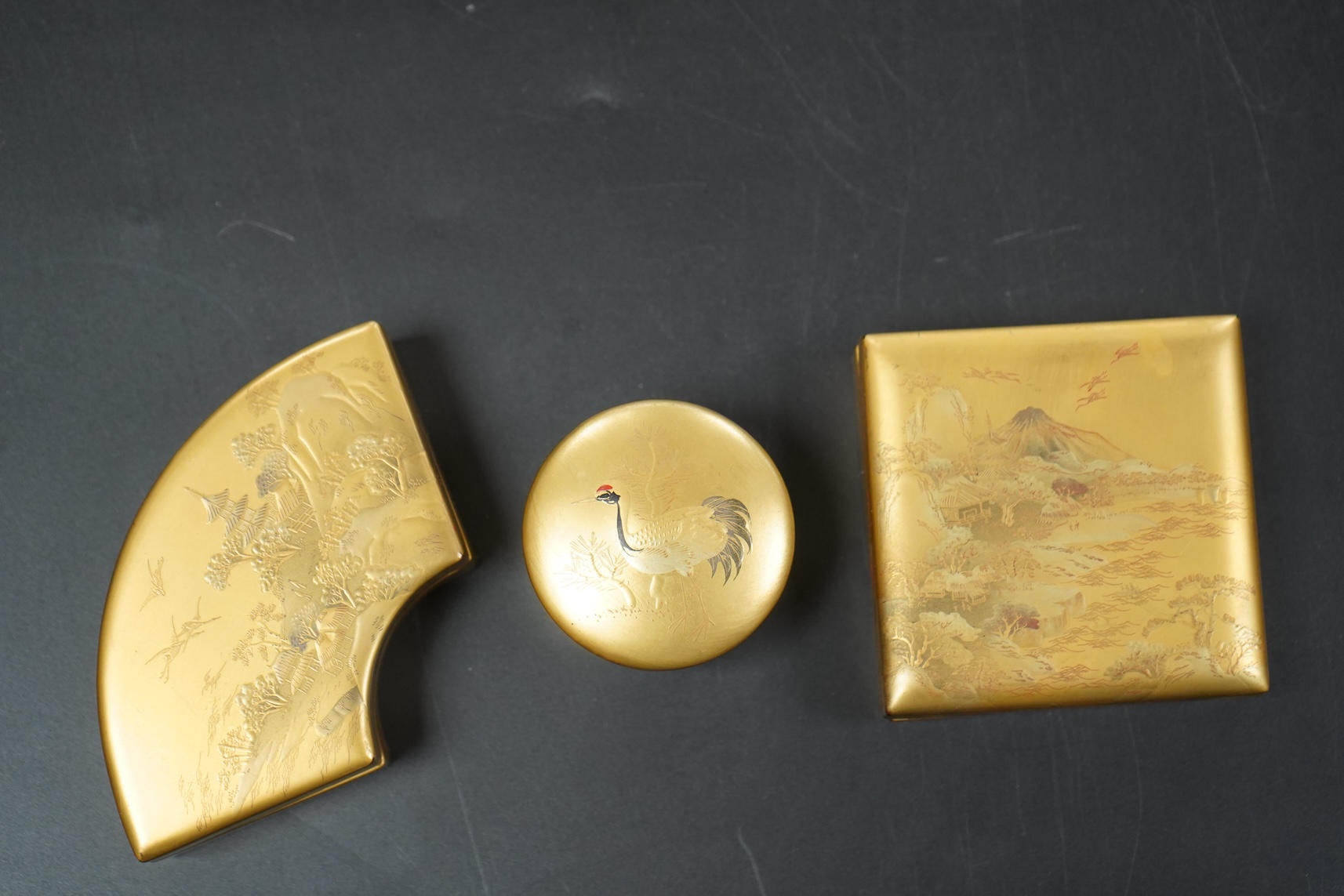 Three Japanese gilt lacquer boxes, one depicting Mount Fuji, largest 9cm wide